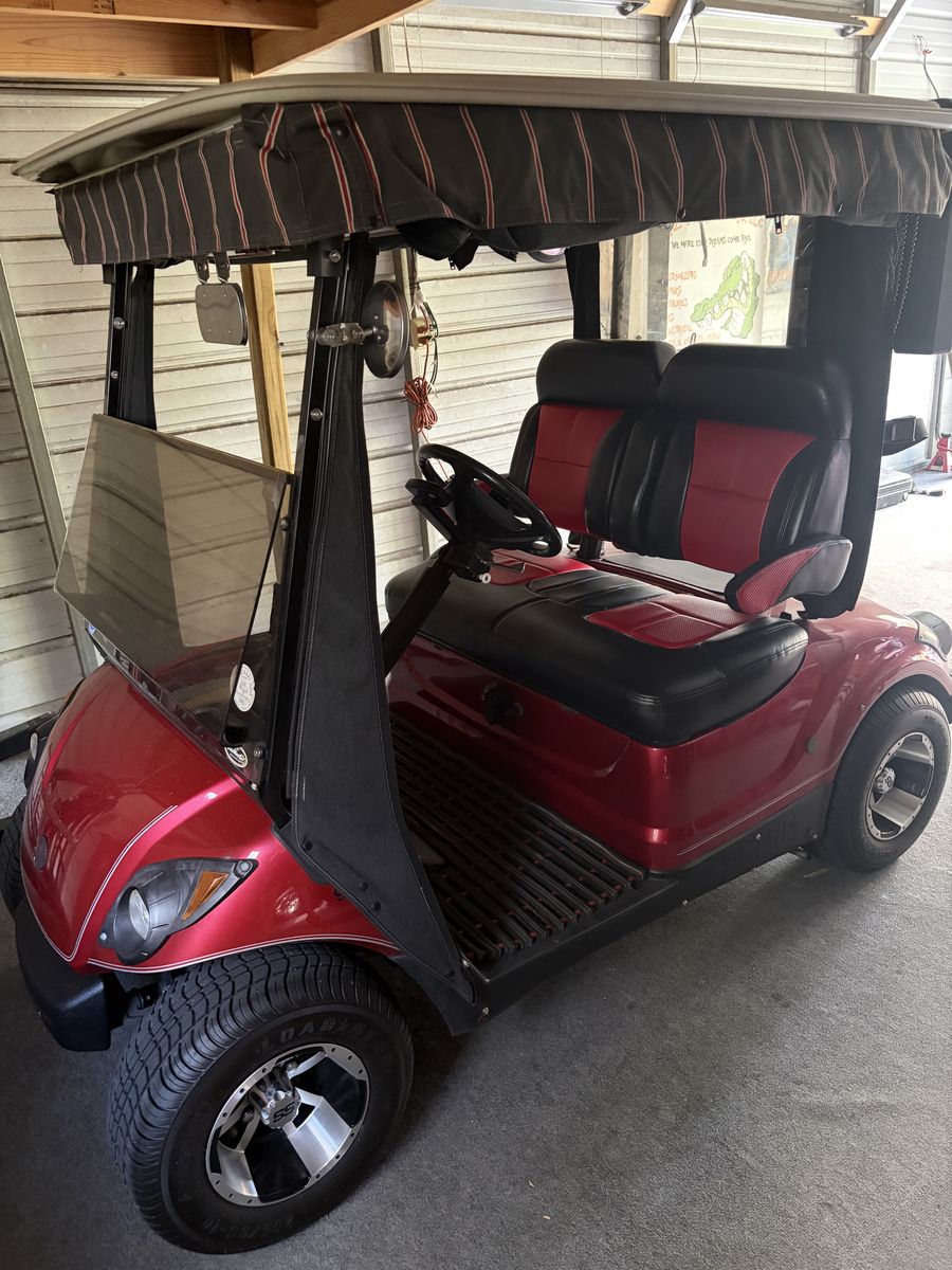 Red 2-passenger gas golf cart with custom red and black bench seat