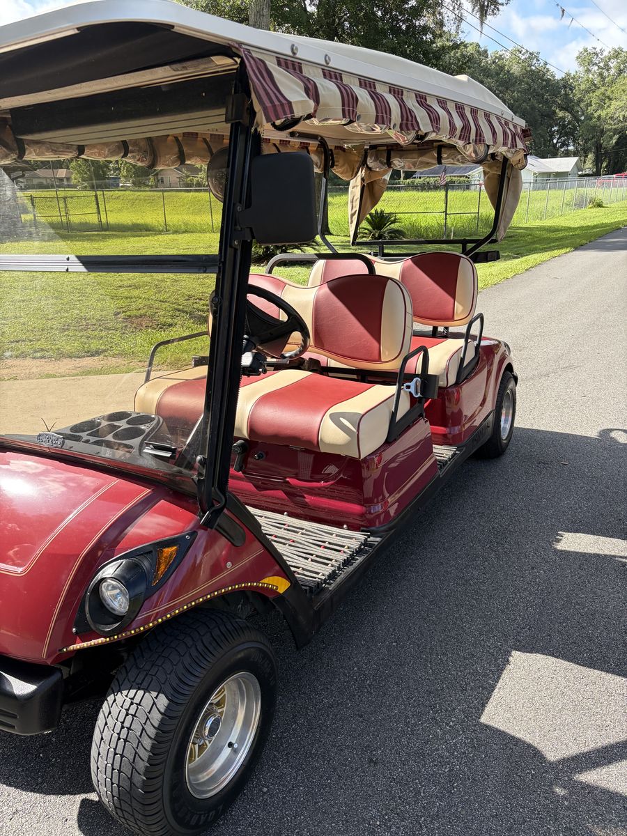 Maroon 4-passenger forward-facing golf cart, both rows facing front