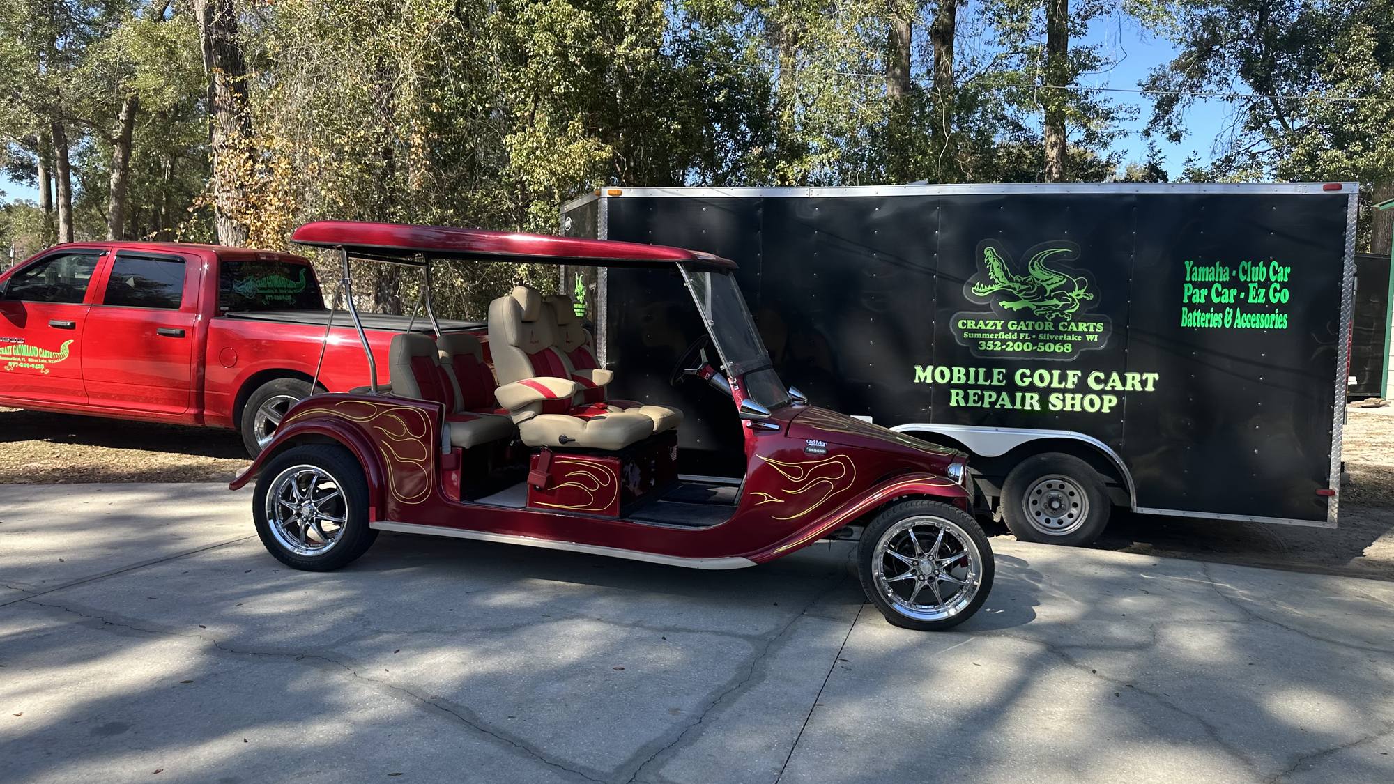 Custom flamed golf cart beside the Crazy Gator Carts mobile golf cart repair trailer